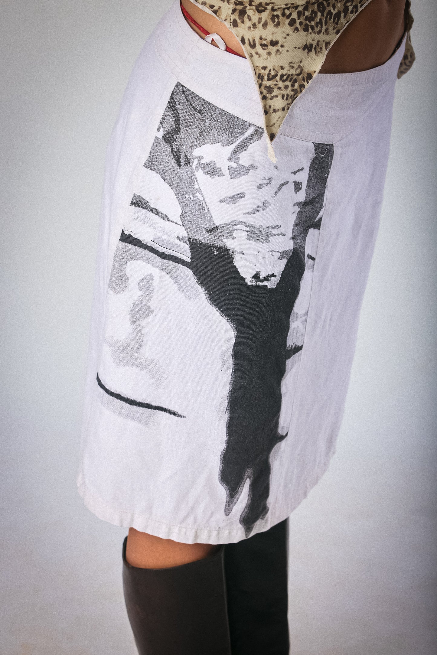 White shirt with black and gray abstract design worn by a person on a plain background
