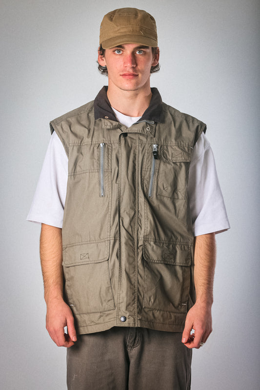 man wearing a waterproof vest no sleeves color olive